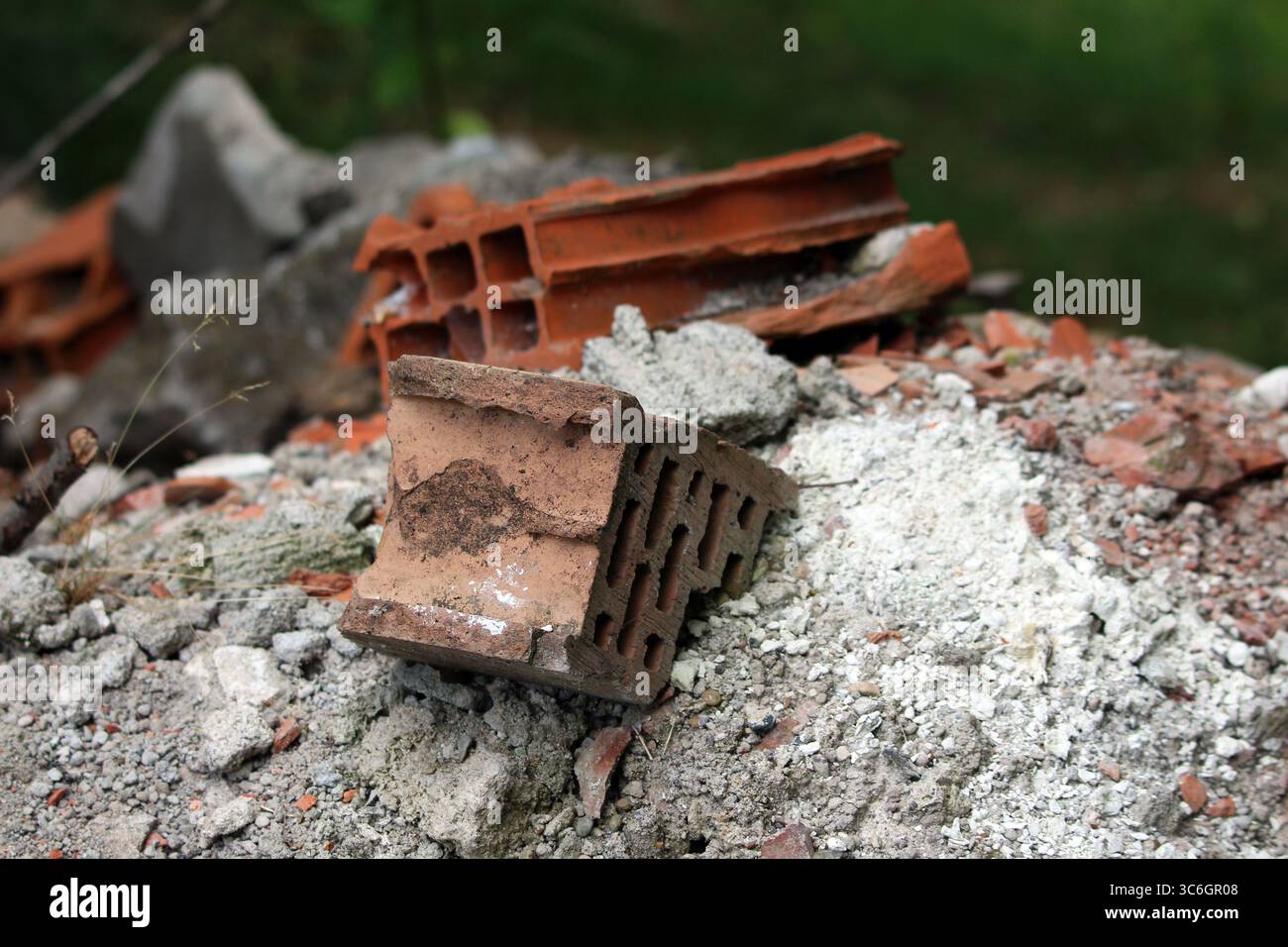 Une pile de briques creuses rouges, de fragments de béton gris et de débris de construction est montrée en détail, représentant les déchets de démolition et les matériaux de construction Banque D'Images