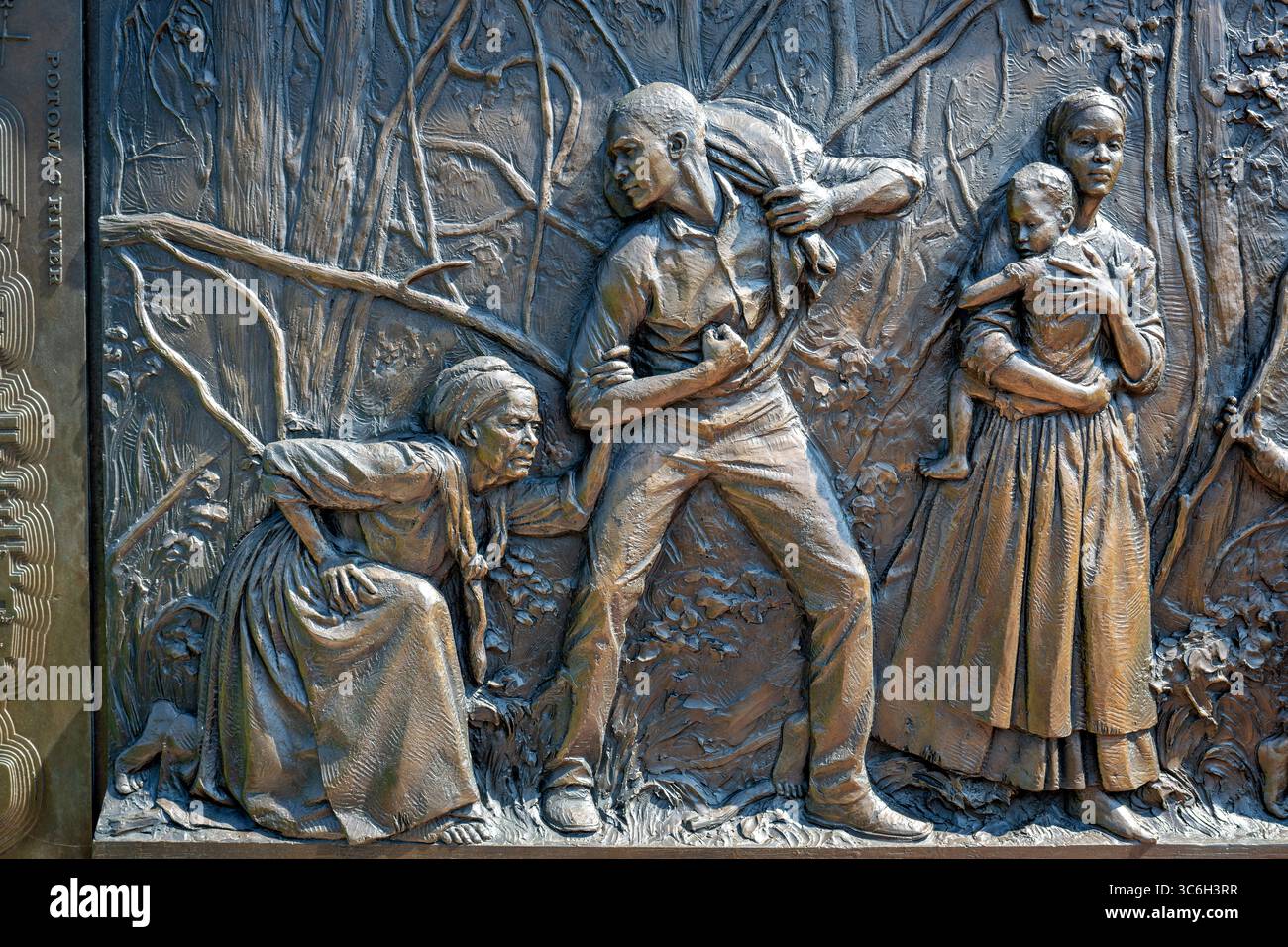 ALEXANDRIA, Virginie — Une sculpture en relief en bronze représente une famille fuyant l'esclavage au mémorial du cimetière des Contrabands et des Freedmen, avec l'inscription « fuir l'esclavage pour un sanctuaire et la liberté à Alexandrie ». L'œuvre du sculpteur local Joanna Blake fait partie du mémorial dédié en 2014 à 1 711 Afro-Américains morts entre 1864-1869 et enterrés dans le cimetière historique. Le cimetière est établi en mars 1864 sur des terres confédérées confisquées pour servir la communauté de contrebande et d'affranchis d'Alexandrie pendant la guerre de Sécession. Le site a acquis une importance nationale à Decemb Banque D'Images