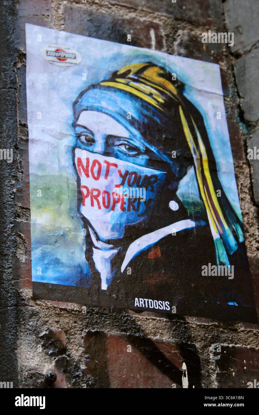 Image Street art de femme avec bandana couvrant le visage portant les mots Not Your Property. Hommage à une fille avec Une boucle d'oreille Pearl dans Melbourne Laneway. Banque D'Images