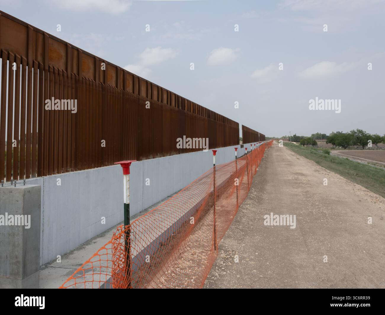 Une vue détaillée du mur frontalier américano-mexicain montrant la structure de la clôture métallique et le terrain, illustrant l'infrastructure de sécurité frontalière. Banque D'Images