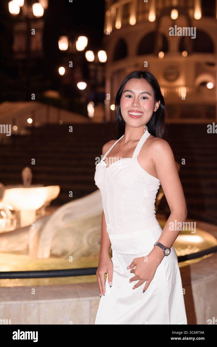 Portrait d'une belle jeune femme asiatique avec de longs cheveux noirs dans la ville de style européen la nuit. Élégante femme touriste en plein air, appréciant Europ pittoresque Banque D'Images
