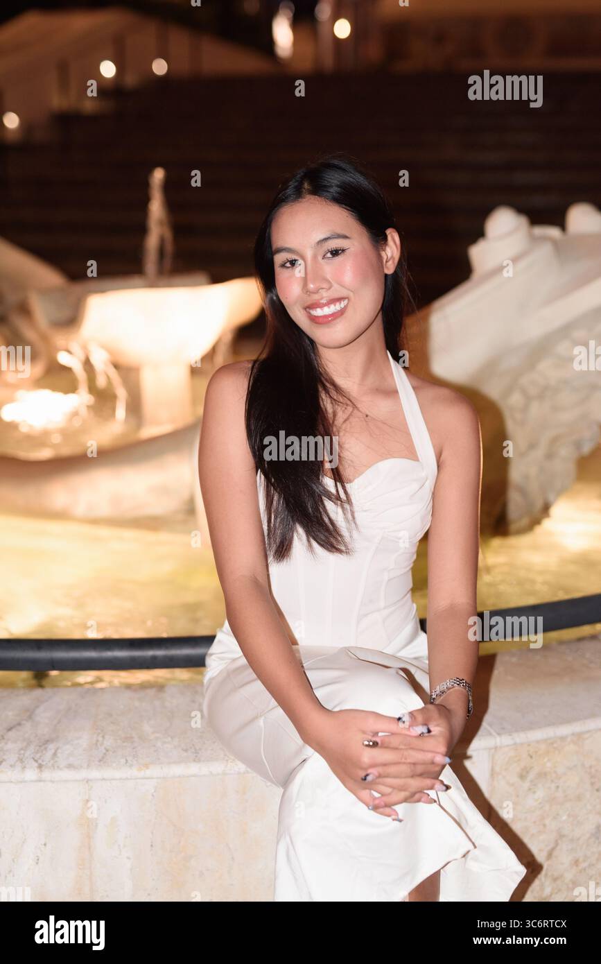 Portrait d'une belle jeune femme asiatique avec de longs cheveux noirs dans la ville de style européen la nuit. Élégante femme touriste en plein air, appréciant Europ pittoresque Banque D'Images