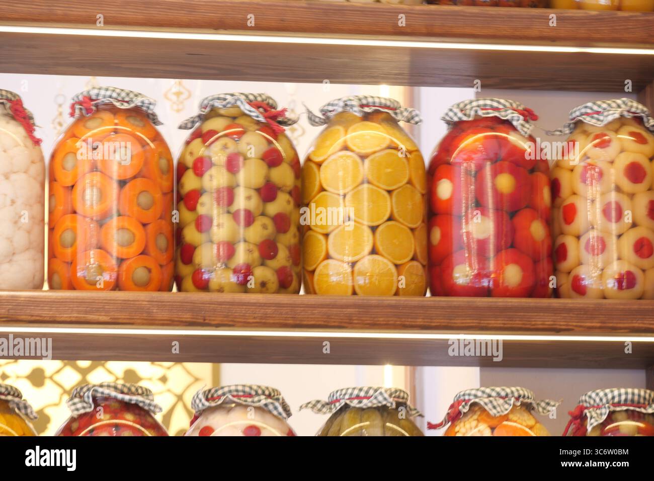 Pots colorés de fruits conservés sur une étagère en bois Banque D'Images