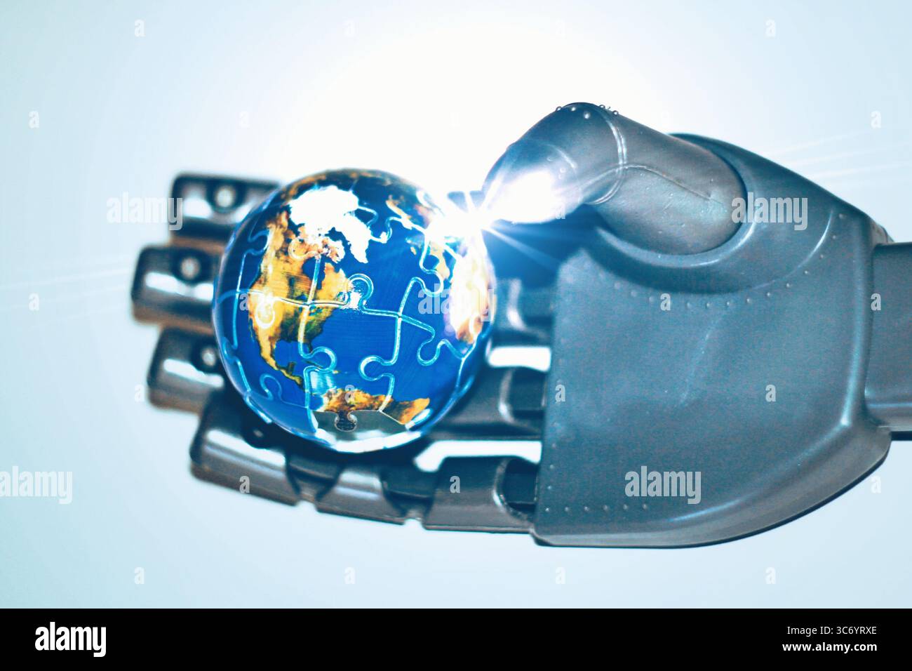 Une main robotique tenant soigneusement une représentation réaliste de la terre Banque D'Images