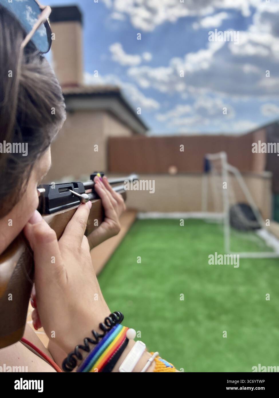 Vue arrière d'une femme utilisant un fusil de visée. Gros plan des mains d'une femme utilisant un fusil. Femme avec un fusil visant quelque part Banque D'Images