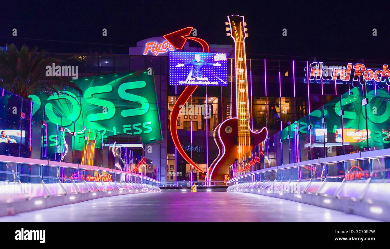 Des panneaux lumineux, y compris le Hard Rock Cafe, au-delà d'une passerelle la nuit à Las Vegas, Nevada, États-Unis Banque D'Images