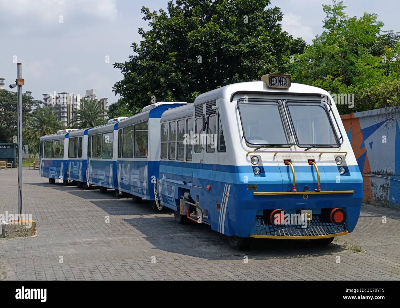 Train jouet bleu et blanc écologique stationné à Eco Park, Kolkata, Inde. Photographié le 23 juillet 2025, lors d'un après-midi ensoleillé. Banque D'Images