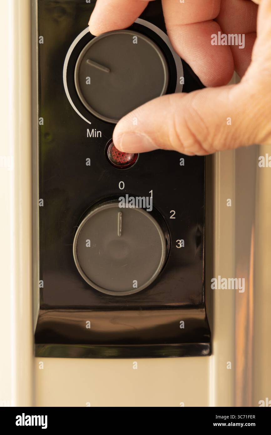Augmentation des prix de l'électricité, réglage du thermostat sur un chauffe-fioul électrique Banque D'Images