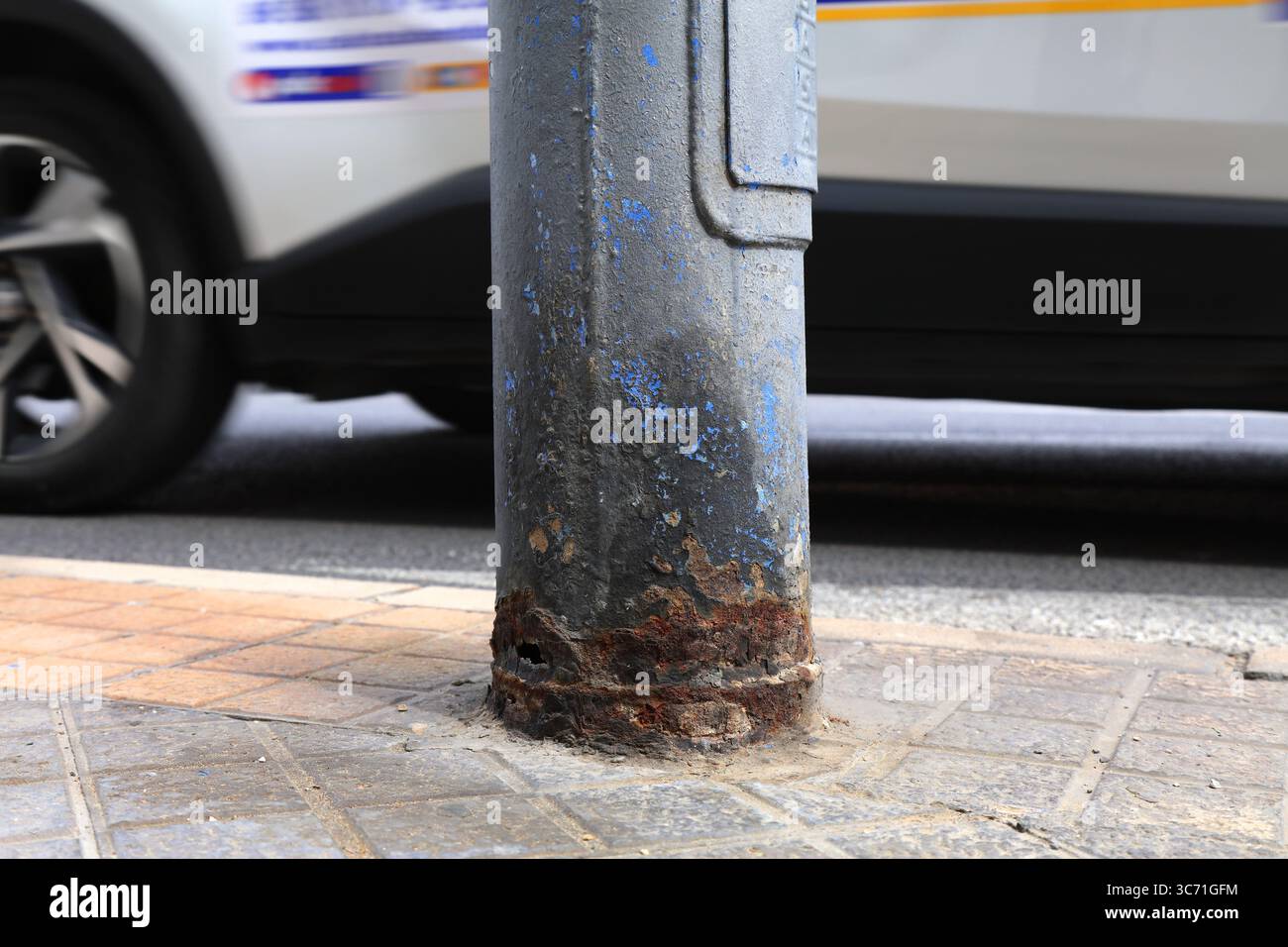 Problème d'infrastructure urbaine - lampadaire public métallique endommagé par des chiens urineurs. Poteau en acier corrodé à Benidorm, Espagne. Banque D'Images