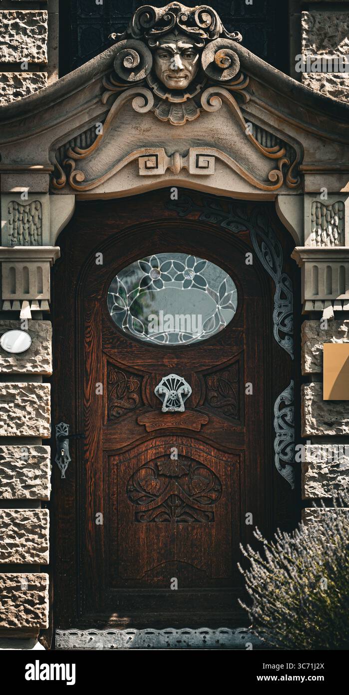 Gros plan d'une porte en bois Art Nouveau ornée à Konstanz Allemagne avec des motifs floraux en bois sculpté complexes et un vitrail expressif Banque D'Images