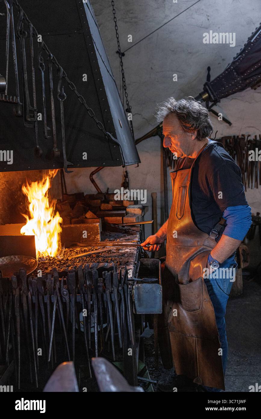 Denis Flageollet, maître horloger et fondateur de de de Bethune, travaille dans sa forge privée où il fabrique à la main des composants horlogers en métal brut. Banque D'Images