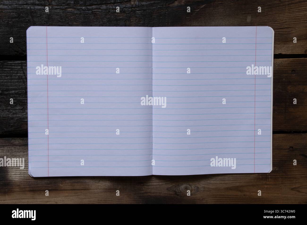 Cahier d'école ouvert doublé sur une table en bois et vue de dessus, pages vierges pour les notes utilisées comme modèle ou arrière-plan Banque D'Images