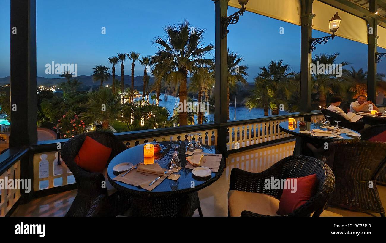 Les touristes apprécient un délicieux dîner sur la terrasse de l'ancien hôtel historique Cataract, surplombant le pittoresque fleuve du nil à Assouan, en Égypte Banque D'Images