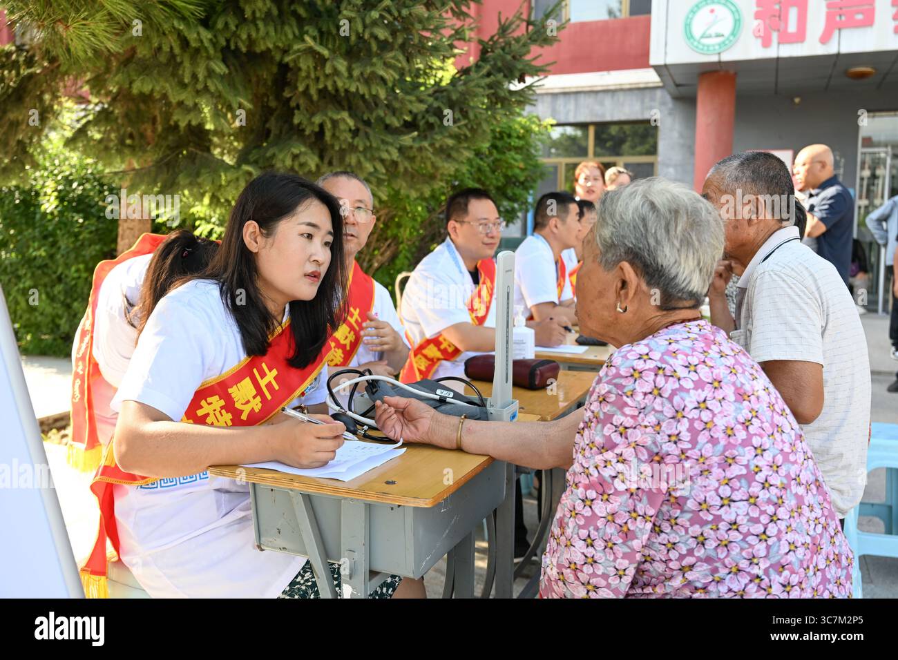 Hohhot, région autonome de Mongolie intérieure de Chine. 1er août 2025. Les travailleurs médicaux (l) offrent des services de consultation gratuits dans un refuge temporaire à Tumd Left Banner de Hohhot, dans la région autonome de Mongolie intérieure du nord de la Chine, 1er août 2025. Les pluies torrentielles récentes ont provoqué des inondations à Tumd Left Banner, entraînant l'évacuation de 17 000 résidents. Les autorités locales ont mis en place 22 abris temporaires et fourni des biens de première nécessité quotidiens tels que des lits, de la nourriture, de l’eau potable et des médicaments aux personnes touchées par les inondations. Crédit : BEI He/Xinhua/Alamy Live News Banque D'Images