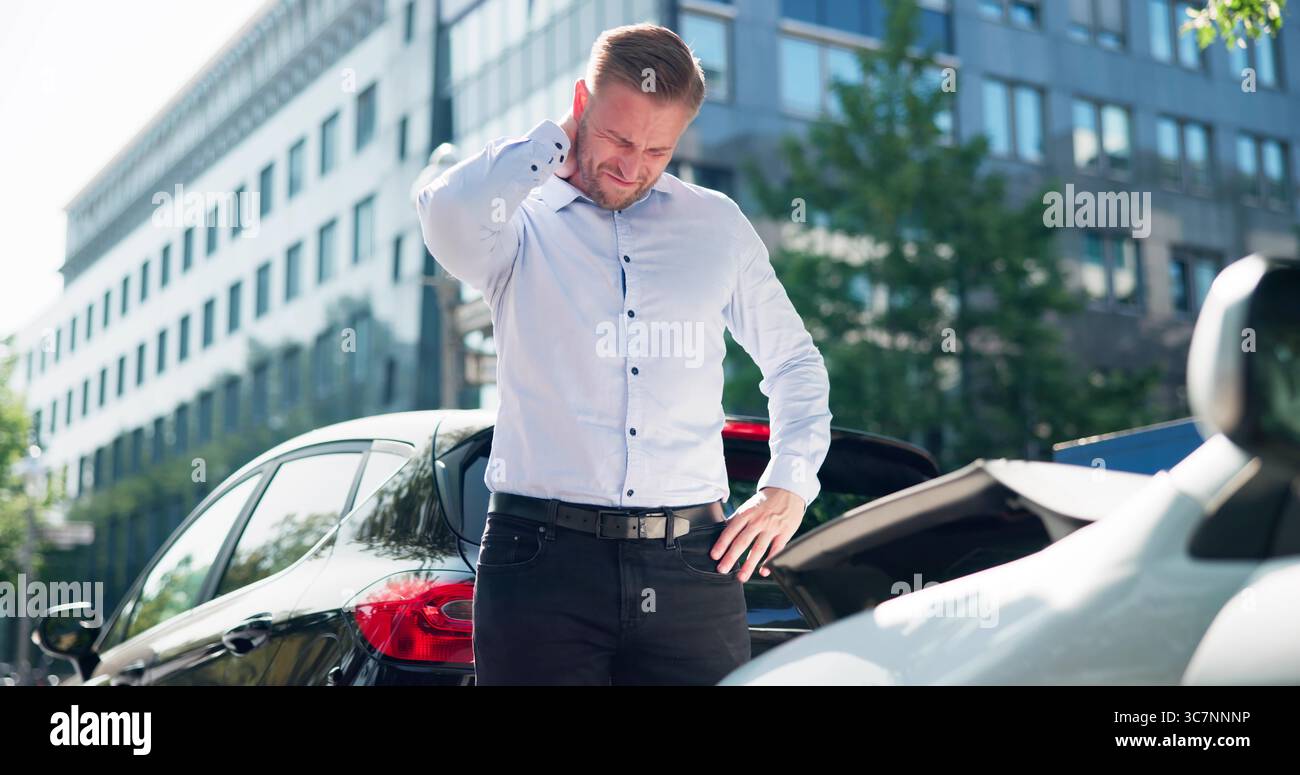 Le jeune homme cherche l'aide juridique après un accident de voiture cause Whiplash. Banque D'Images