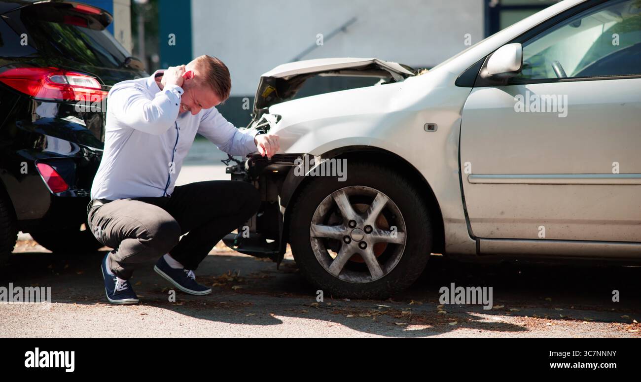 Jeune homme demande réparation après une blessure de voiture a causé la douleur de Whiplash. Banque D'Images