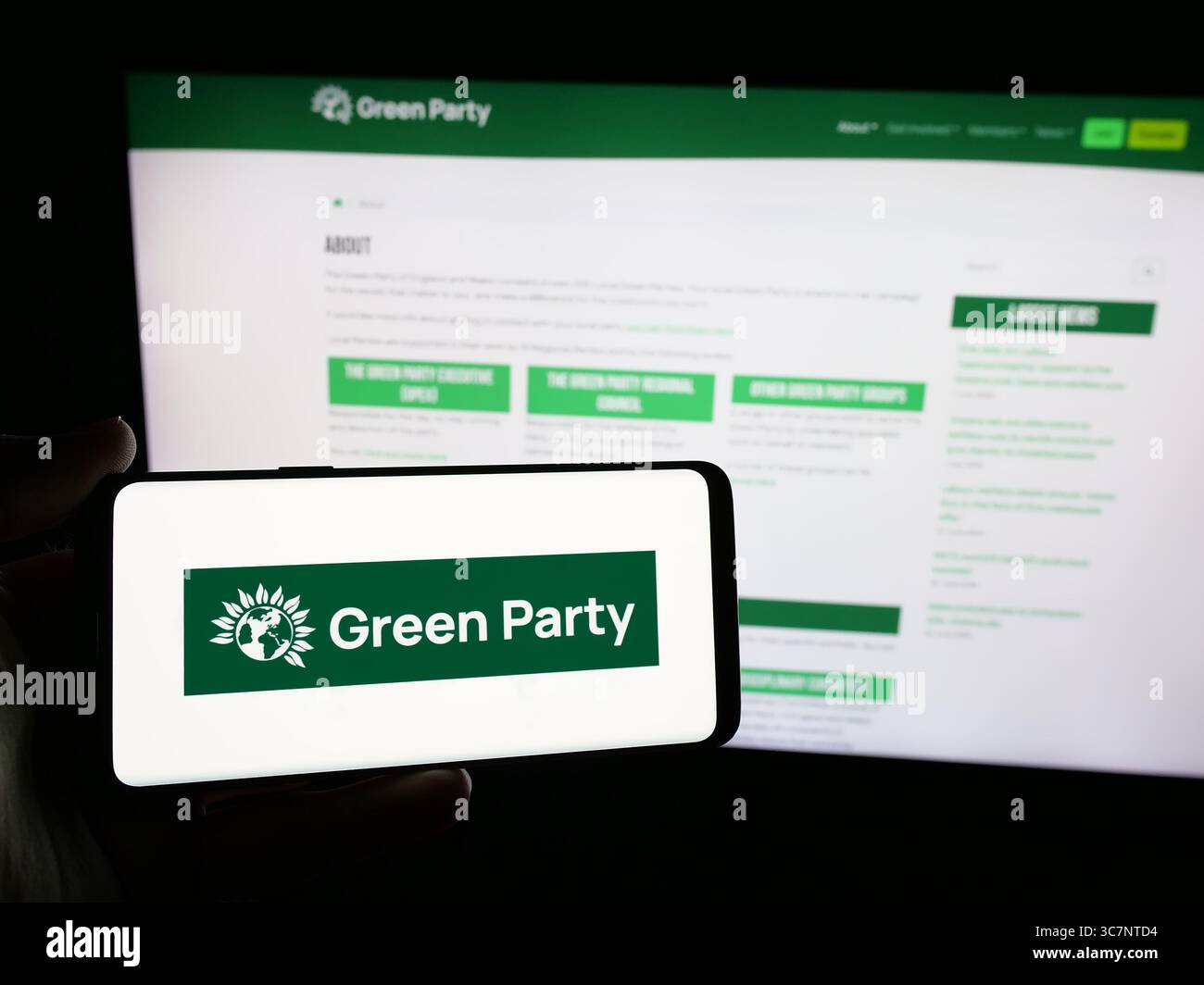 Stuttgart, Allemagne - 07-09-2025 : personne tenant un smartphone avec le logo du Parti vert d'Angleterre et du pays de Galles (GPEW) sur l'écran devant le site Web Banque D'Images