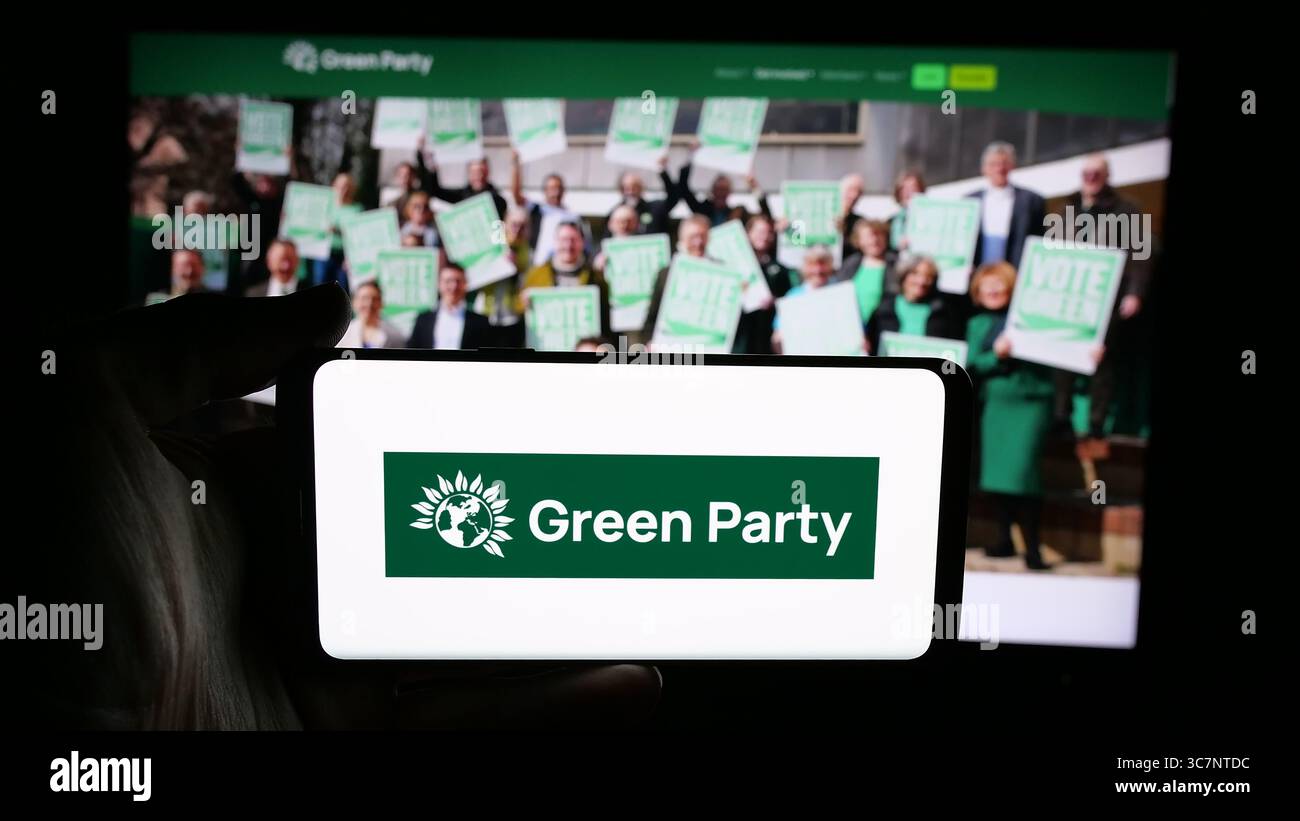 Stuttgart, Allemagne - 07-09-2025 : personne tenant un téléphone portable avec le logo du Parti Vert d'Angleterre et du pays de Galles (GPEW) sur l'écran devant la page web. Banque D'Images