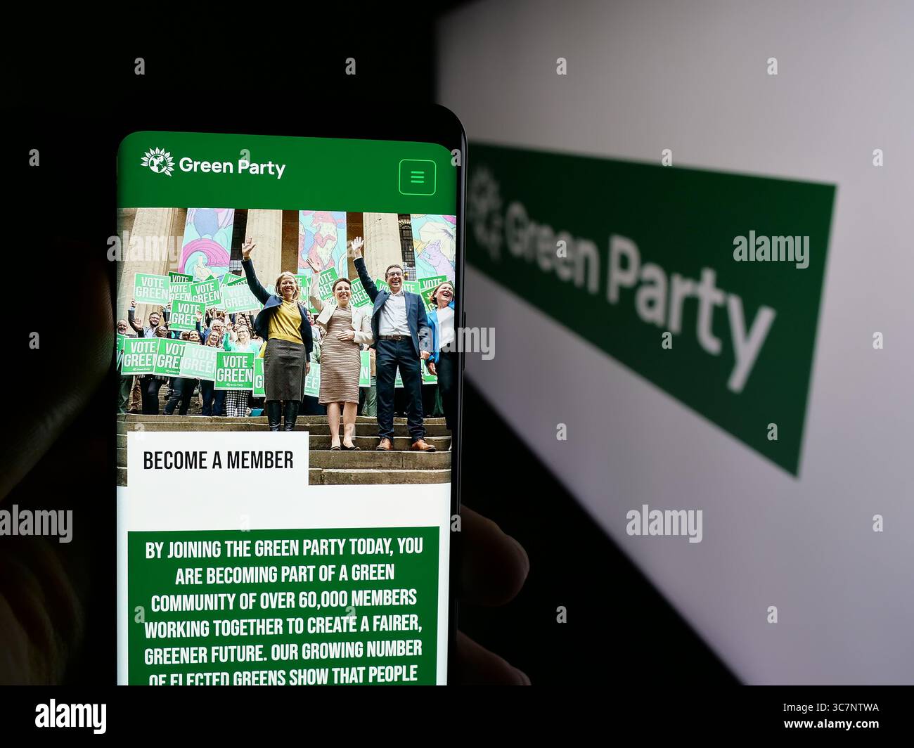 Stuttgart, Allemagne - 07-09-2025 : personne tenant un smartphone avec la page web du Parti Vert d'Angleterre et du pays de Galles (GPEW) sur l'écran devant le logo. Banque D'Images