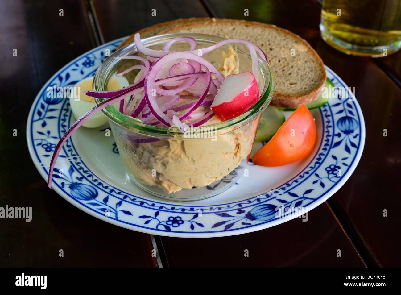 Tartinade au fromage bavarois Obatzda, Obazda ou Obatzter garnie d'oignons et de pain servie avec une bière Helles Lager Banque D'Images