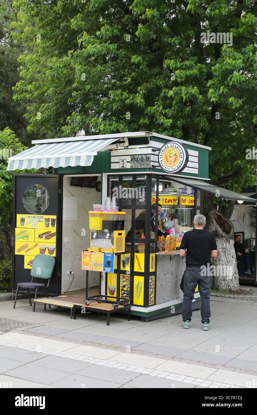 Pristina, Kosovo-27 mai 2025 : Client non identifié achetant de la nourriture et des boissons par le vendeur assis sur Mother Teresa Boulevard Banque D'Images