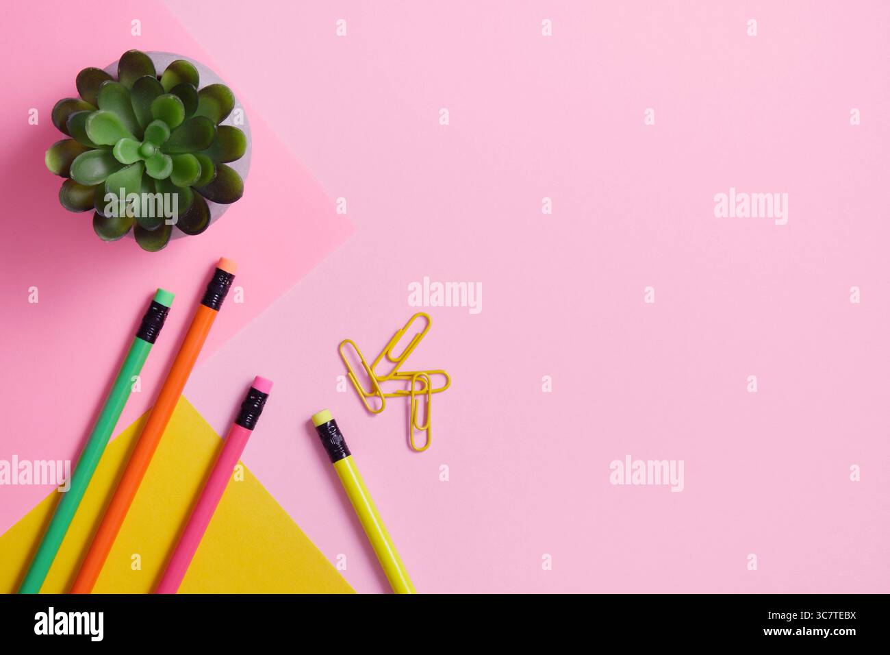 Crayons et trombones sur un fond roh et jaune. Espace pour votre texte. Banque D'Images