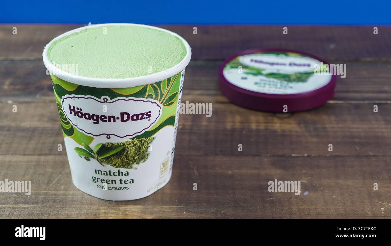 NORWALK, CT, États-Unis - 1er AOÛT 2025 : un récipient blanc contenant de la crème glacée au thé vert matcha vert Haagen Dazs, placé sur une surface en bois rustique. Le colorf Banque D'Images