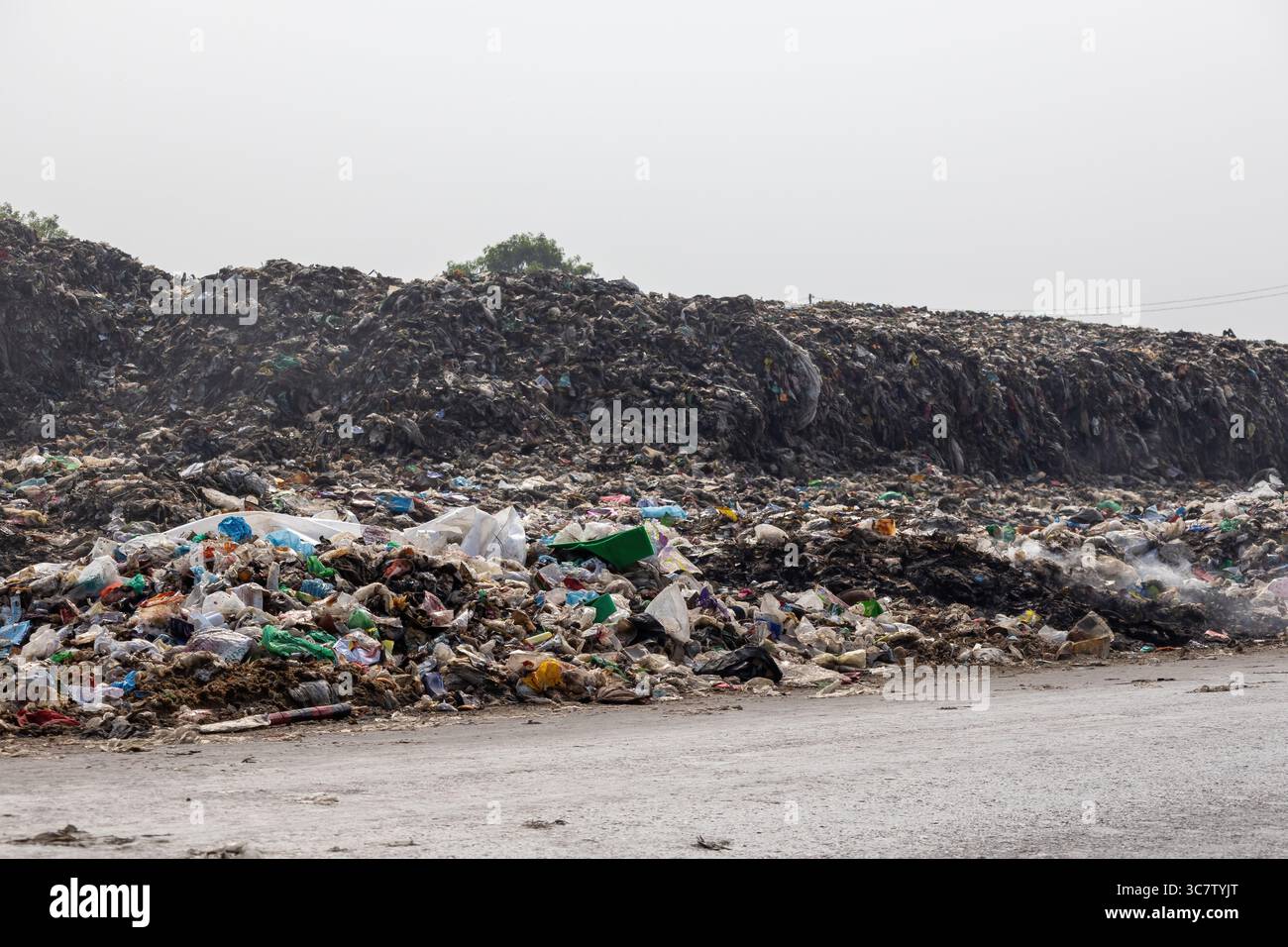 Des piles de déchets ménagers sont laissées sur le bord de la route. Déverser des déchets de cette manière est polluant pour l'environnement. Banque D'Images
