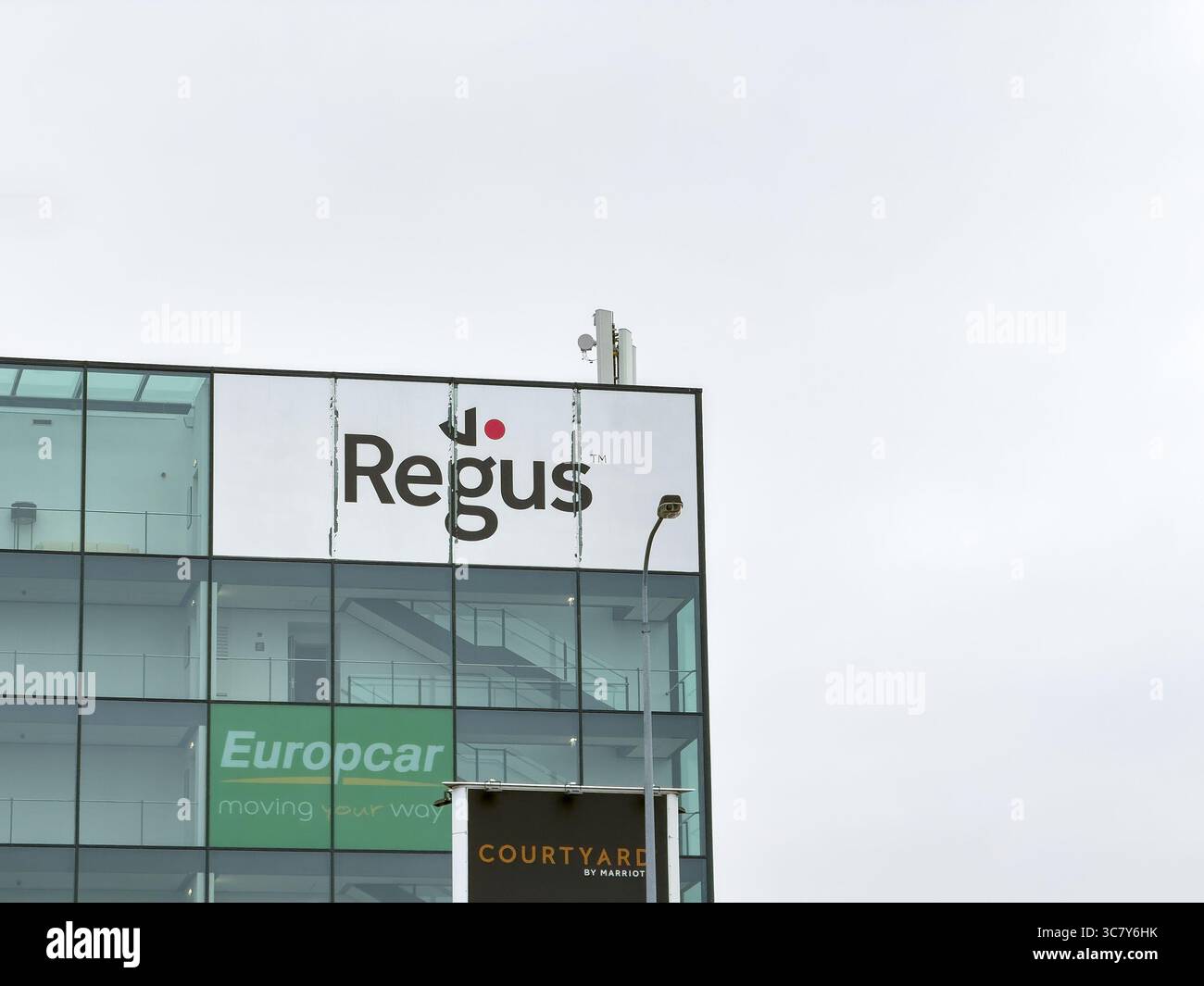 Prague, Tchéquie - 2 novembre 2024 : bannière de la société Regus proposant des bureaux virtuels sur des bâtiments modernes et Europcar Banque D'Images