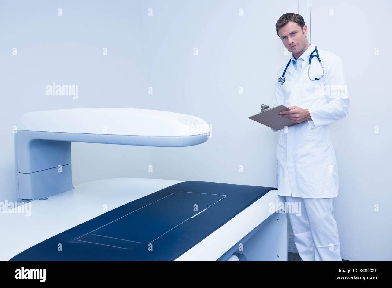Scanner d'imagerie médicale inactif dans la salle d'examen clinique, avec planchette à pince à côté du scanner Banque D'Images
