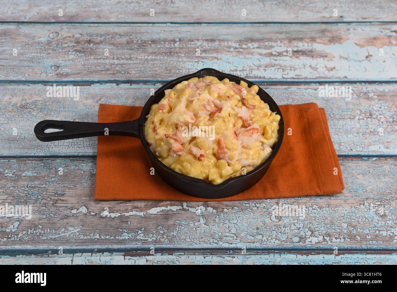 Une mini poêle en fonte remplie de délicieux mac de homard crémeux et de fromage. Banque D'Images