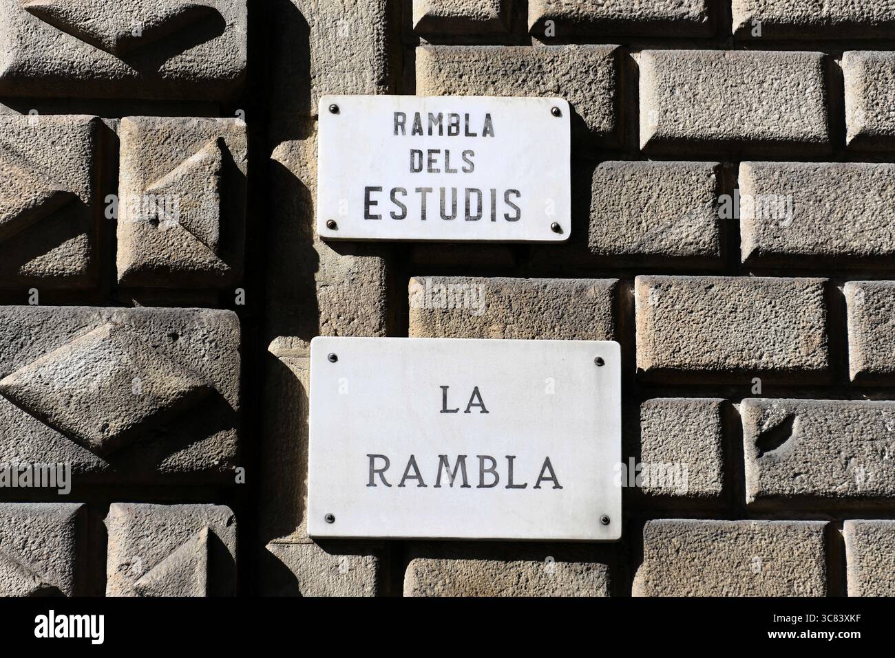 Panneaux de rue historiques sur un mur de pierre texturé, Barcelone, Catalogne, Espagne Banque D'Images