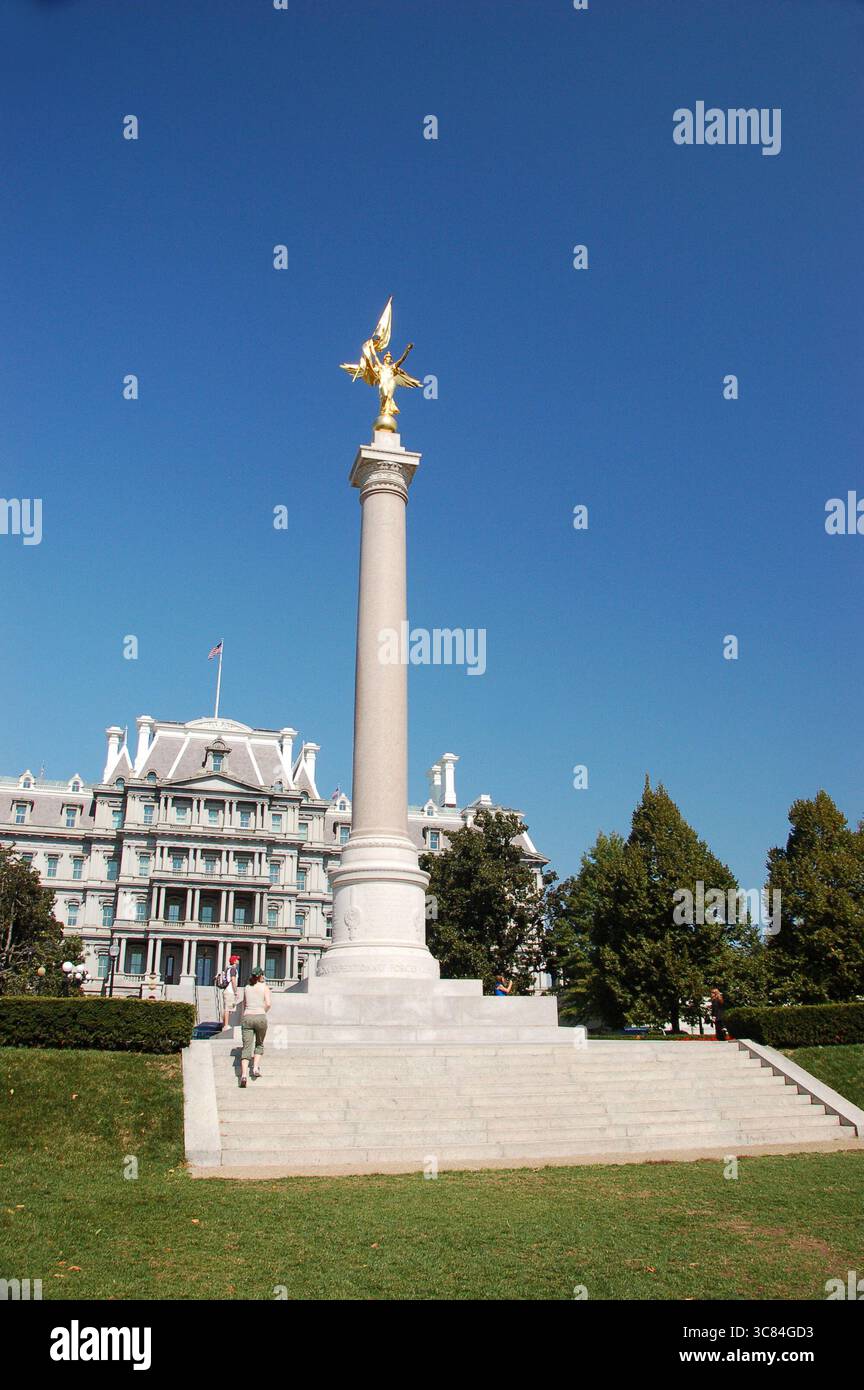 Statue dorée au sommet d'une haute colonne avec le bâtiment du bureau exécutif Eisenhower en arrière-plan sous un ciel bleu clair à Washington, D.C. Banque D'Images