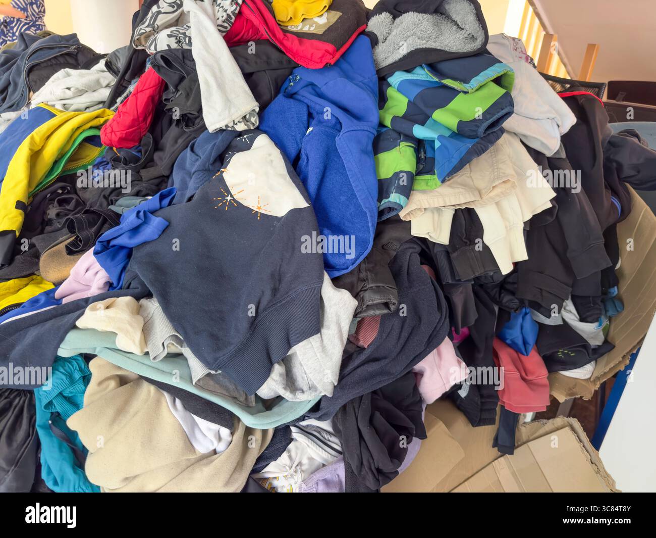 Vêtements abandonnés sur une table pliée – scène d'occasion ou de centre de dons Banque D'Images