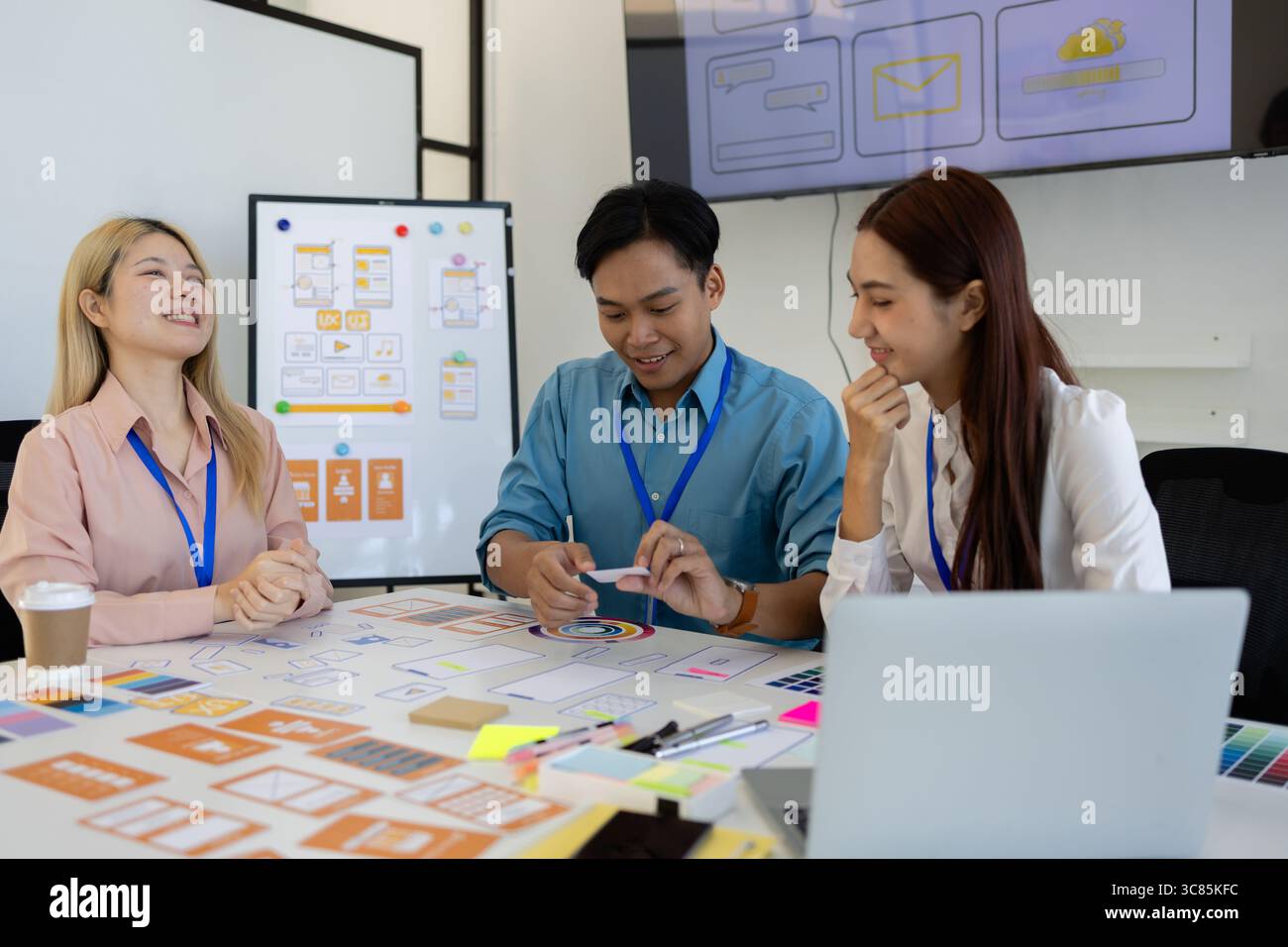 les concepteurs ux, ui, web et d'applications mobiles discutent de l'aspect et de la convivialité du site web ou de l'application qu'ils conçoivent, y compris des schémas de couleurs et des mises en page Banque D'Images