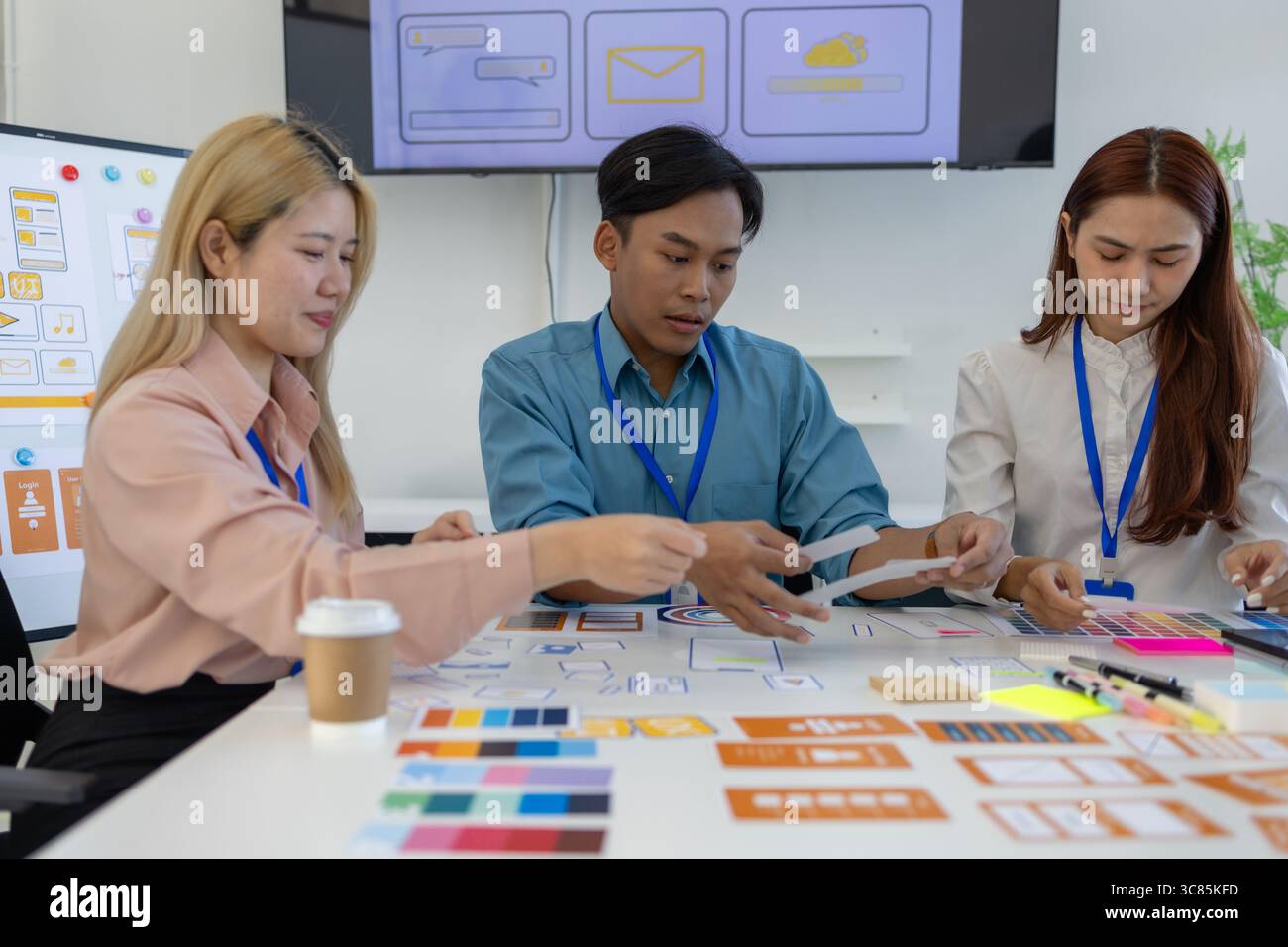 les concepteurs ux, ui, web et d'applications mobiles discutent de l'aspect et de la convivialité du site web ou de l'application qu'ils conçoivent, y compris des schémas de couleurs et des mises en page Banque D'Images