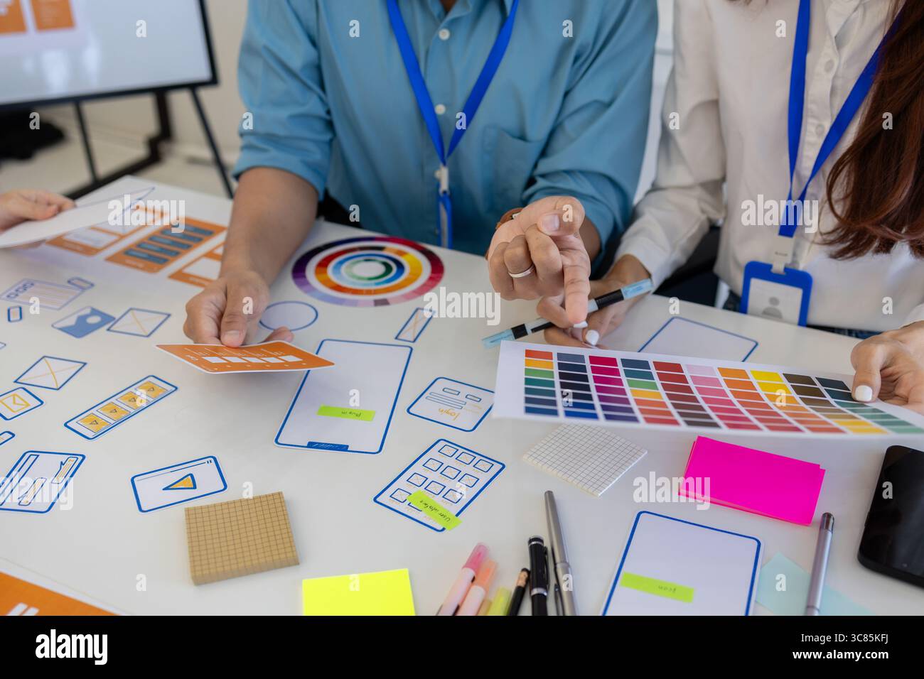 les concepteurs ux, ui, web et d'applications mobiles discutent de l'aspect et de la convivialité du site web ou de l'application qu'ils conçoivent, y compris des schémas de couleurs et des mises en page Banque D'Images