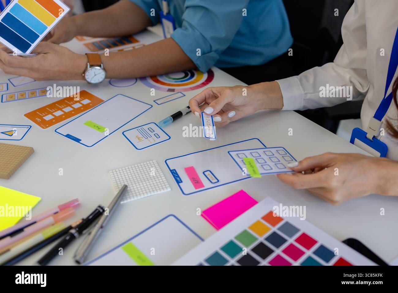 les concepteurs ux, ui, web et d'applications mobiles discutent de l'aspect et de la convivialité du site web ou de l'application qu'ils conçoivent, y compris des schémas de couleurs et des mises en page Banque D'Images