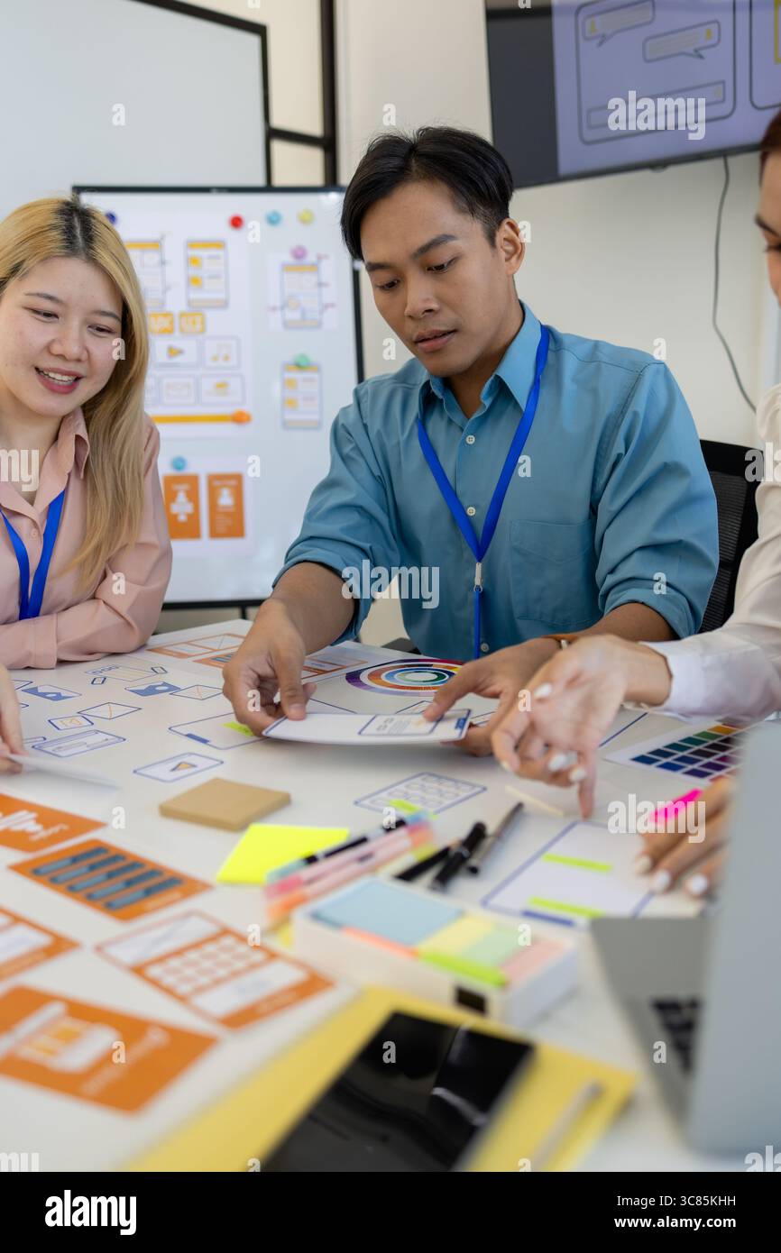 les concepteurs ux, ui, web et d'applications mobiles discutent de l'aspect et de la convivialité du site web ou de l'application qu'ils conçoivent, y compris des schémas de couleurs et des mises en page Banque D'Images