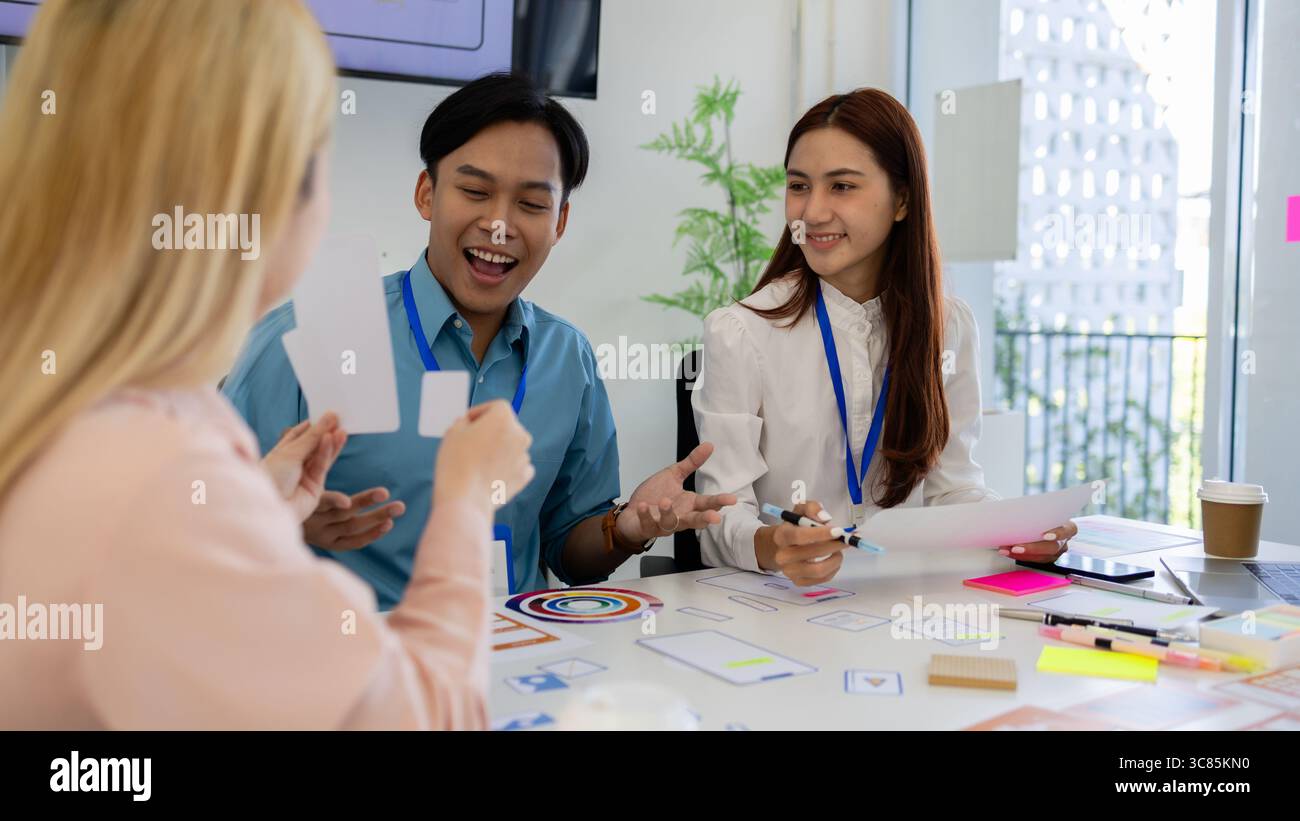 les concepteurs ux, ui, web et d'applications mobiles discutent de l'aspect et de la convivialité du site web ou de l'application qu'ils conçoivent, y compris des schémas de couleurs et des mises en page Banque D'Images