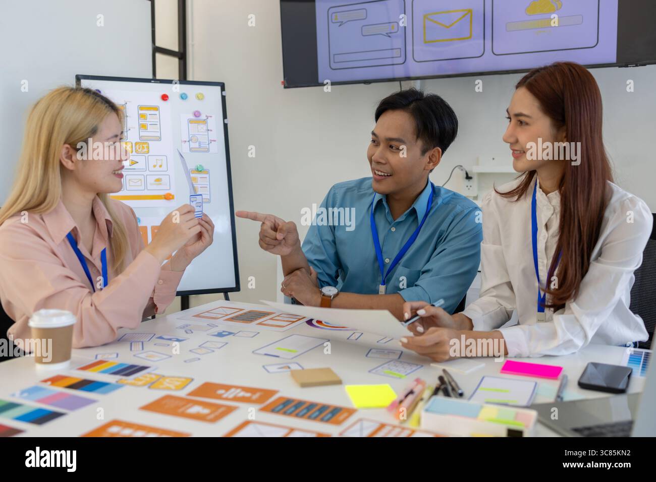 les concepteurs ux, ui, web et d'applications mobiles discutent de l'aspect et de la convivialité du site web ou de l'application qu'ils conçoivent, y compris des schémas de couleurs et des mises en page Banque D'Images