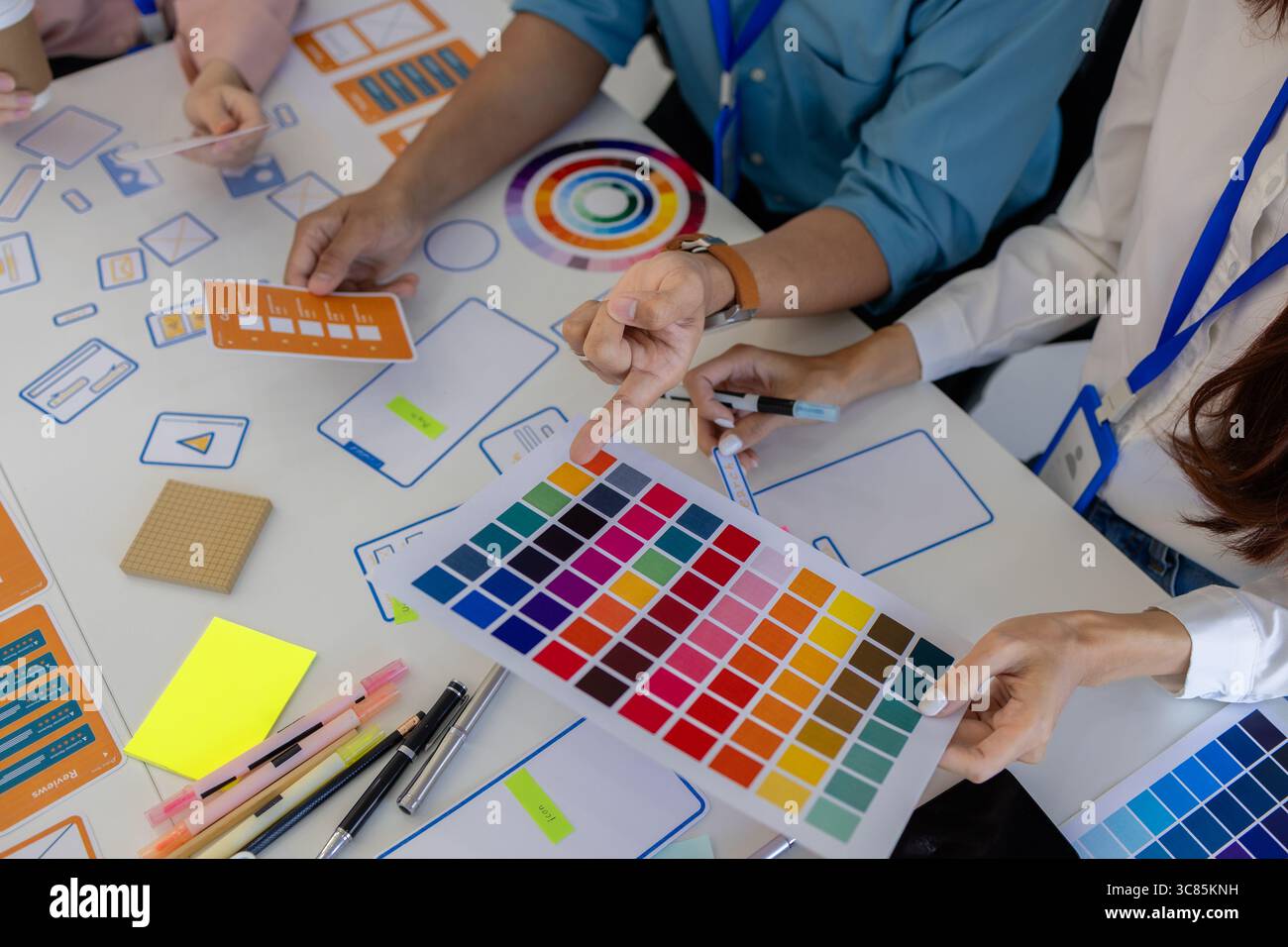 les concepteurs ux, ui, web et d'applications mobiles discutent de l'aspect et de la convivialité du site web ou de l'application qu'ils conçoivent, y compris des schémas de couleurs et des mises en page Banque D'Images