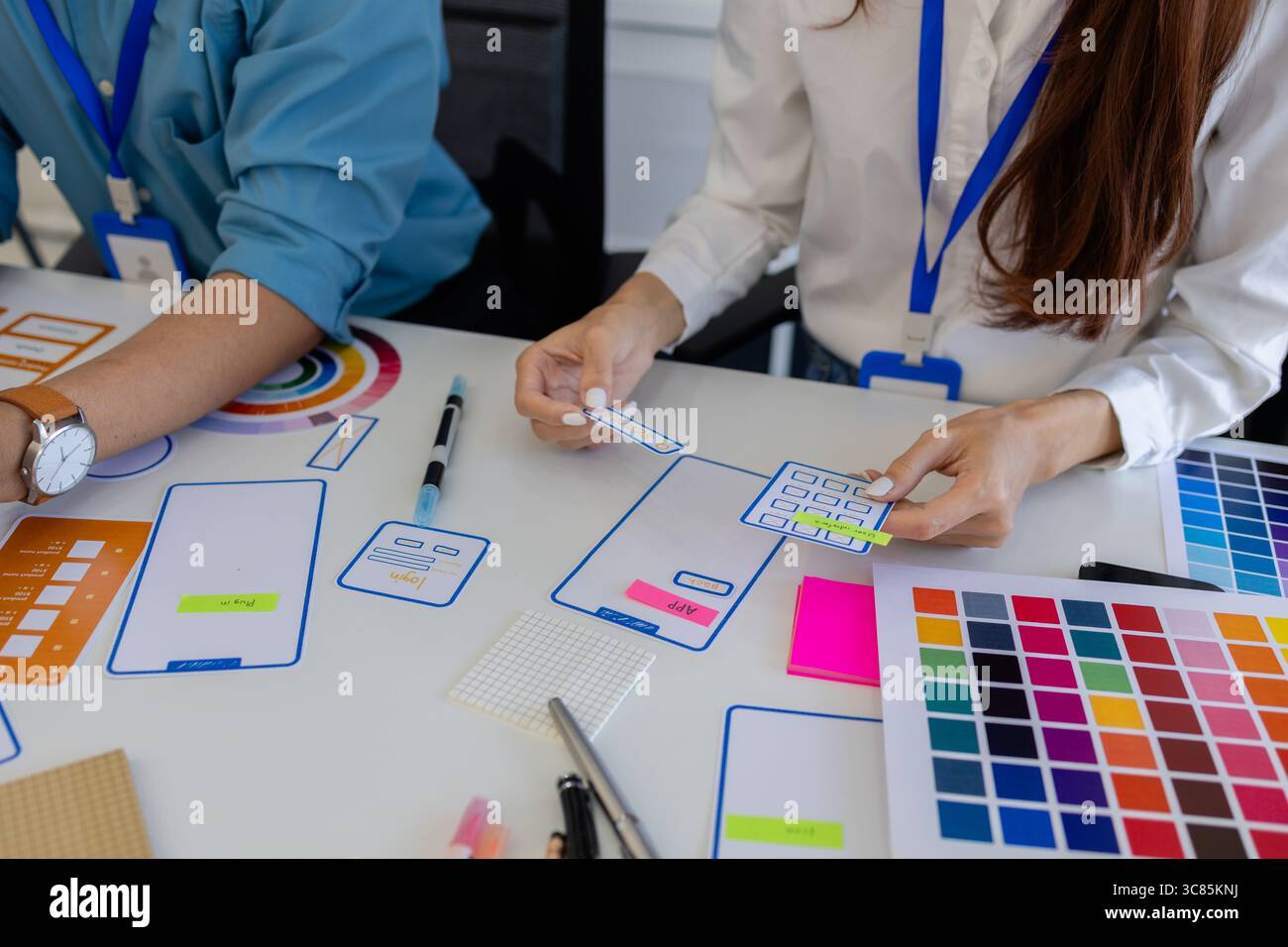 les concepteurs ux, ui, web et d'applications mobiles discutent de l'aspect et de la convivialité du site web ou de l'application qu'ils conçoivent, y compris des schémas de couleurs et des mises en page Banque D'Images