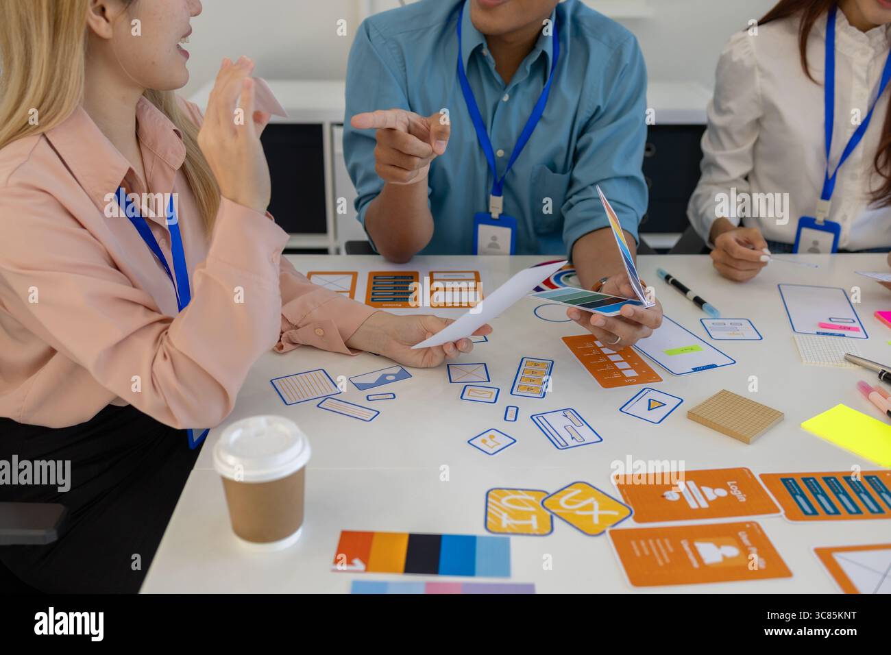 les concepteurs ux, ui, web et d'applications mobiles discutent de l'aspect et de la convivialité du site web ou de l'application qu'ils conçoivent, y compris des schémas de couleurs et des mises en page Banque D'Images