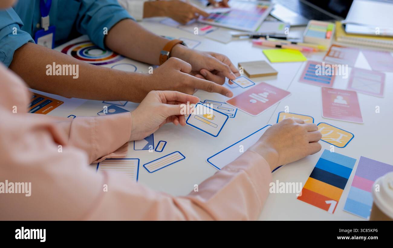 les concepteurs ux, ui, web et d'applications mobiles discutent de l'aspect et de la convivialité du site web ou de l'application qu'ils conçoivent, y compris des schémas de couleurs et des mises en page Banque D'Images