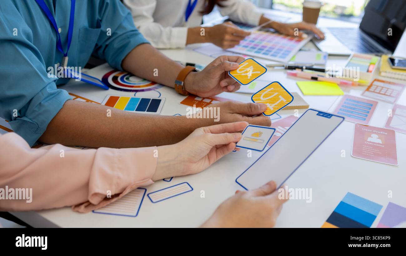 les concepteurs ux, ui, web et d'applications mobiles discutent de l'aspect et de la convivialité du site web ou de l'application qu'ils conçoivent, y compris des schémas de couleurs et des mises en page Banque D'Images