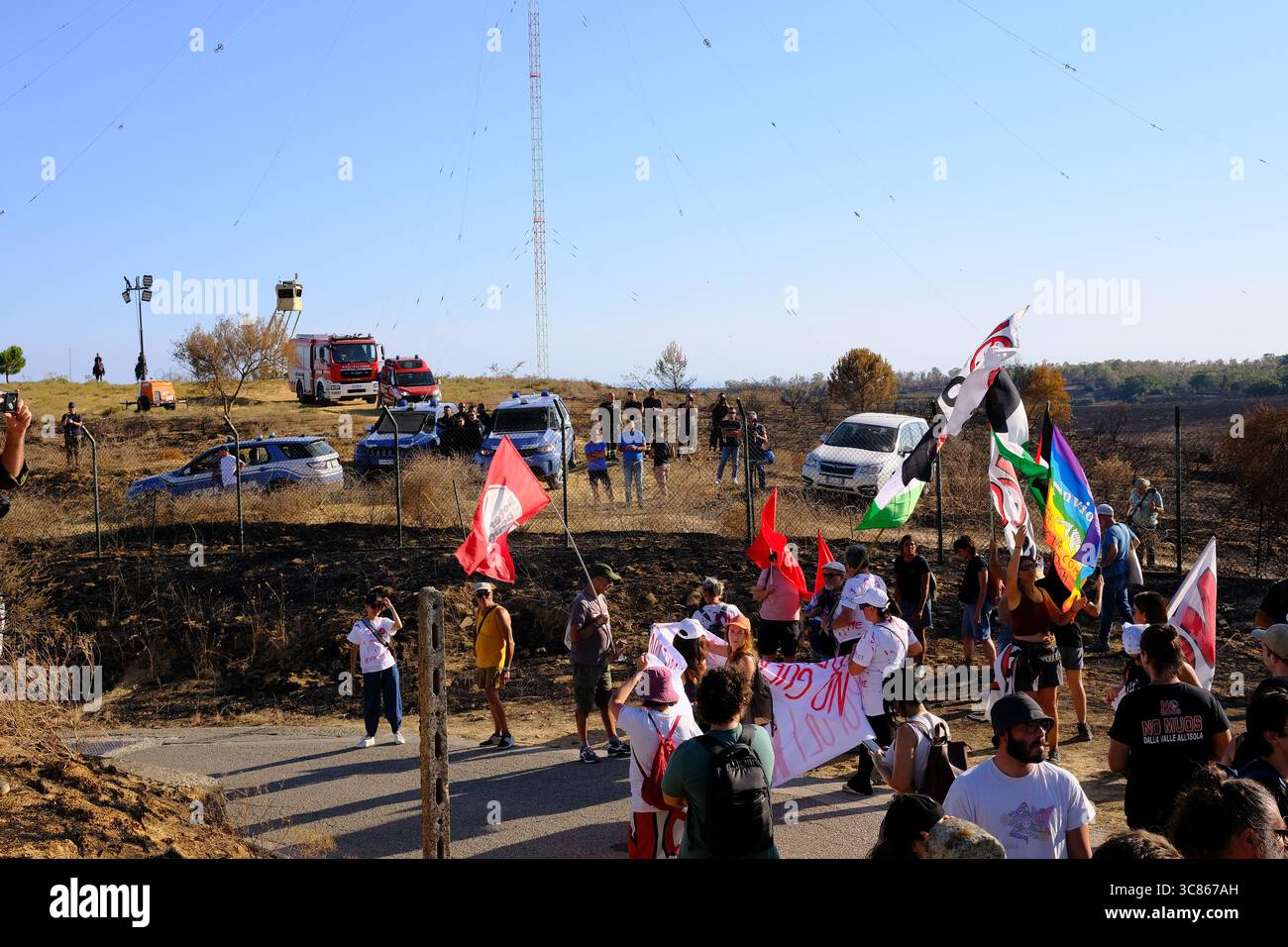 Niscemi, Sicile – 2 août 2025. Manifestation contre le système de communication par satellite MUOS militaire américain basé à l'intérieur de la réserve naturelle de Sughereta à Niscemi. Des centaines de militants du No MUOS se sont rassemblés près du site pour protester contre la présence continue de l'infrastructure militaire américaine sur le territoire sicilien. La manifestation a comporté des discours et une Assemblée en plein air où les participants se sont assis sur la route pour écouter et discuter des propositions. Une forte présence des jeunes et plusieurs organisations environnementales et pacifistes y ont participé. Crédit : Alessio Tricani/Alamy Live News Banque D'Images