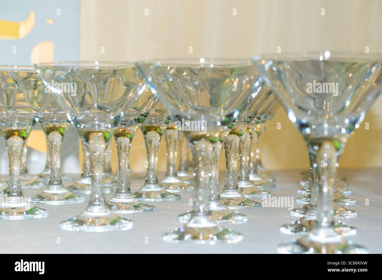 La verrerie étincelante est soigneusement disposée sur une table, reflétant magnifiquement la lumière. La configuration fait allusion à une occasion de célébration qui se déroule dans un gai Banque D'Images