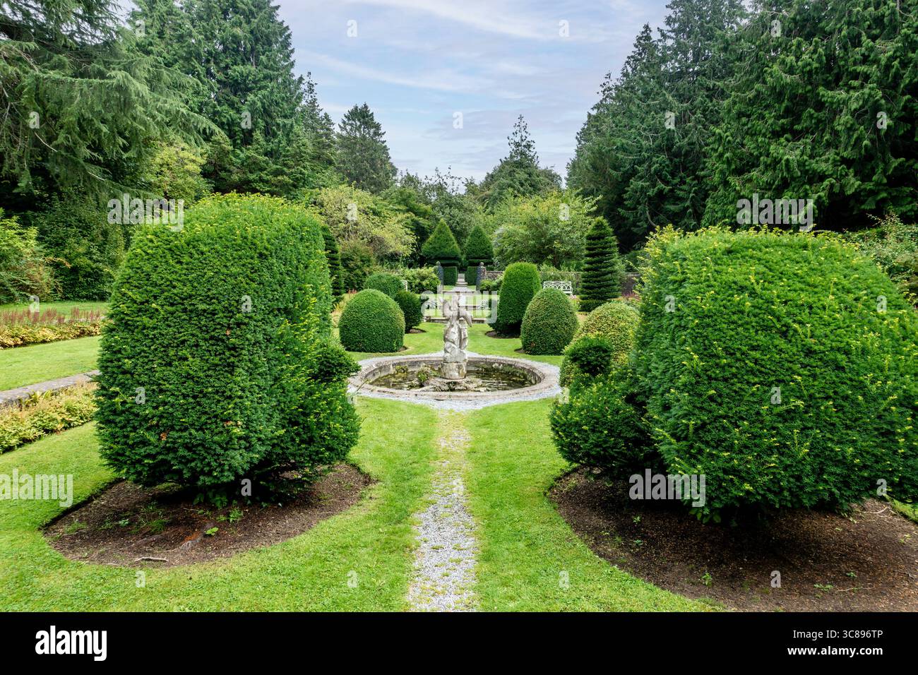 Jardin coulé à Farmleigh, Phoenix Park, Dublin. Paysage formel avec des if coupés, des chemins de gravier, fontaine centrale et des bancs encadrés par de grands evergr Banque D'Images