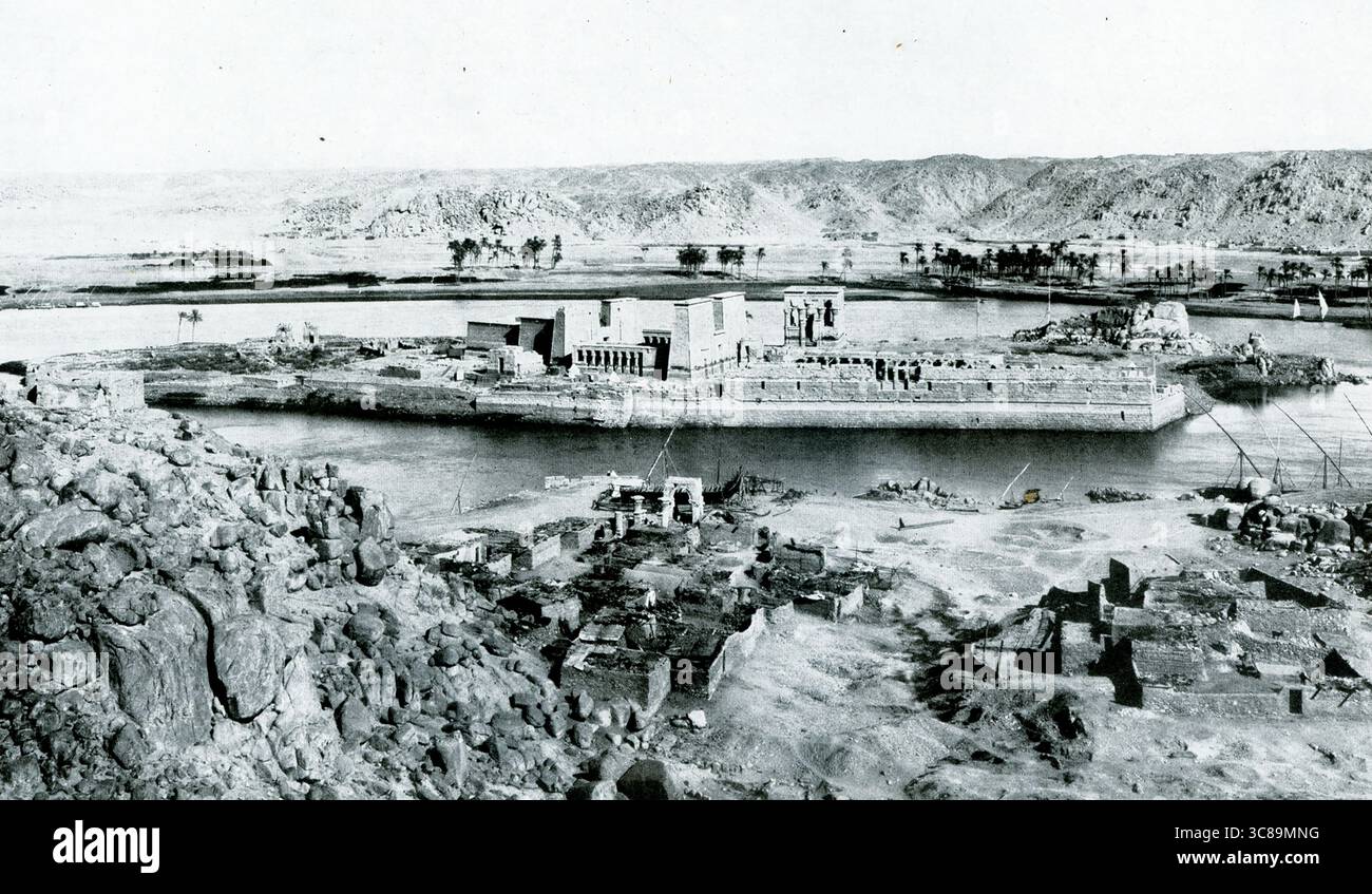 Cette photo datant de 1925 montre l'île égyptienne de Philae.. Construit en 280 av. J.-C., sous le règne de Ptolémée II (période gréco-romaine égyptienne), le temple d'Isis à Philae est dédié à Isis, Osiris et Horus. Les murs du temple contiennent des scènes de la mythologie égyptienne d'Isis ramenant Osiris à la vie, donnant naissance à Horus, et momifiant Osiris après sa mort. La minuscule île de Philae mesure 450 mètres de long et moins de 150 mètres de large. Le déménagement du temple est devenu nécessaire en raison des changements spectaculaires des niveaux d'eau après la construction du barrage d'Assouan en 1902. Banque D'Images
